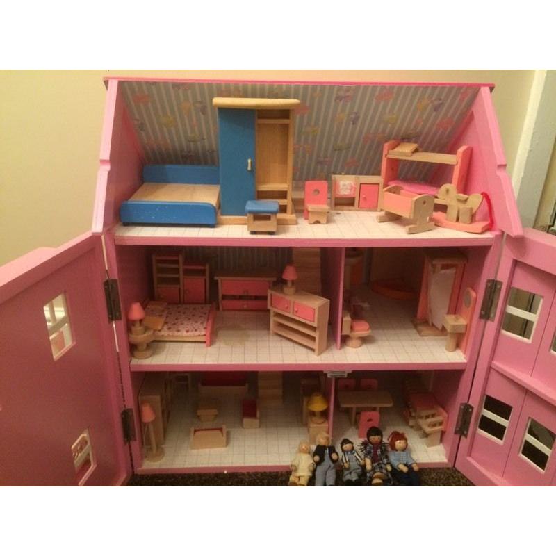 Pink wooden dolls house with furniture