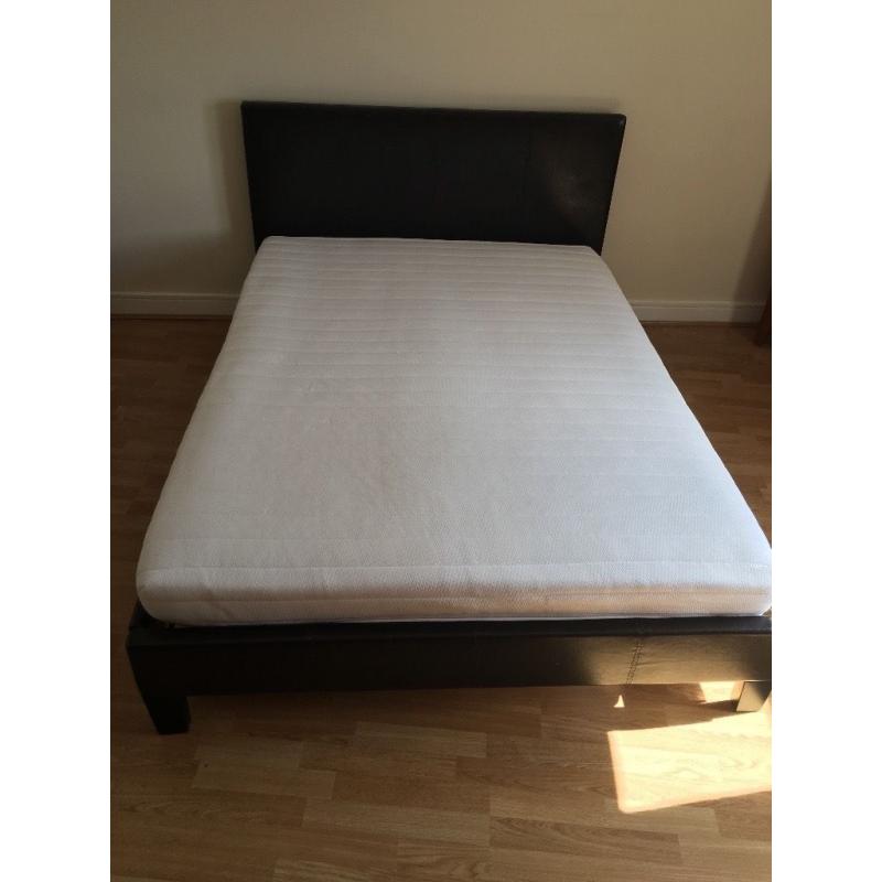 Dark brown double bed with mattress.