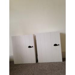 Two wooden bathroom wall cabinets with whale design handles